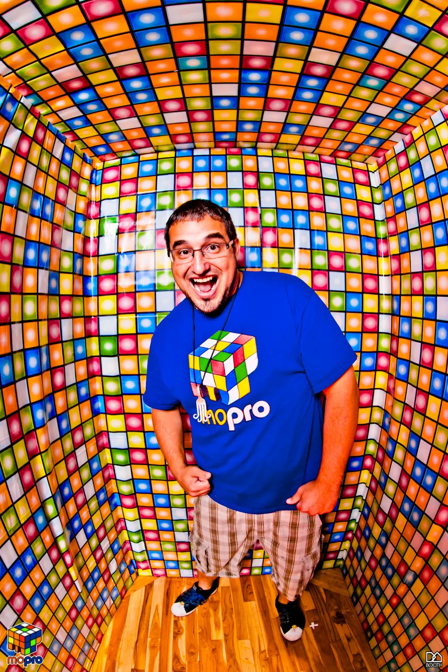 Full-length photo of MontsDe in a Mo'Pro shirt standing in a room covered in colorful square tiles