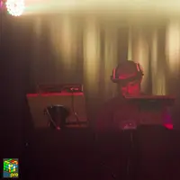 DJ playing behind a hazy curtain of warm stage lights
