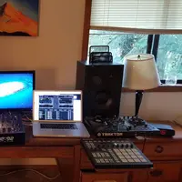 Home studio desk with studio monitors, a keyboard controller, pads and a laptop