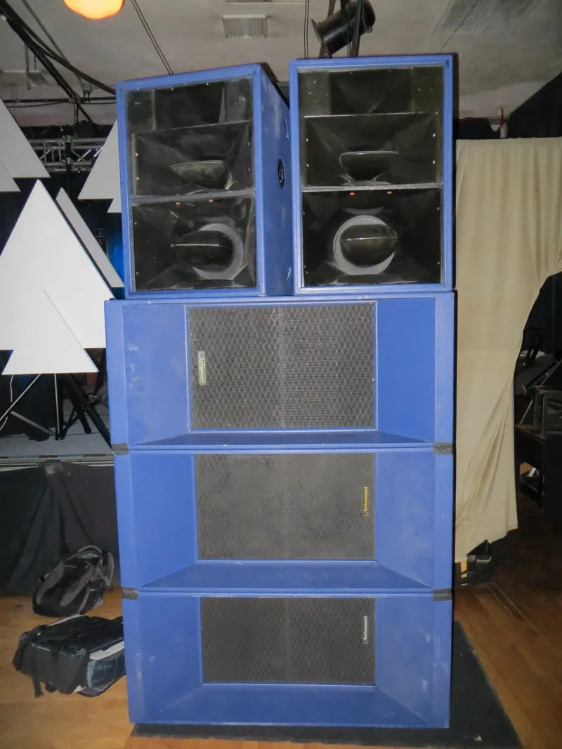 Four-high stack of blue speaker cabinets on a dance floor